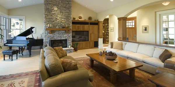 Living room with a stone fireplace and a grand piano